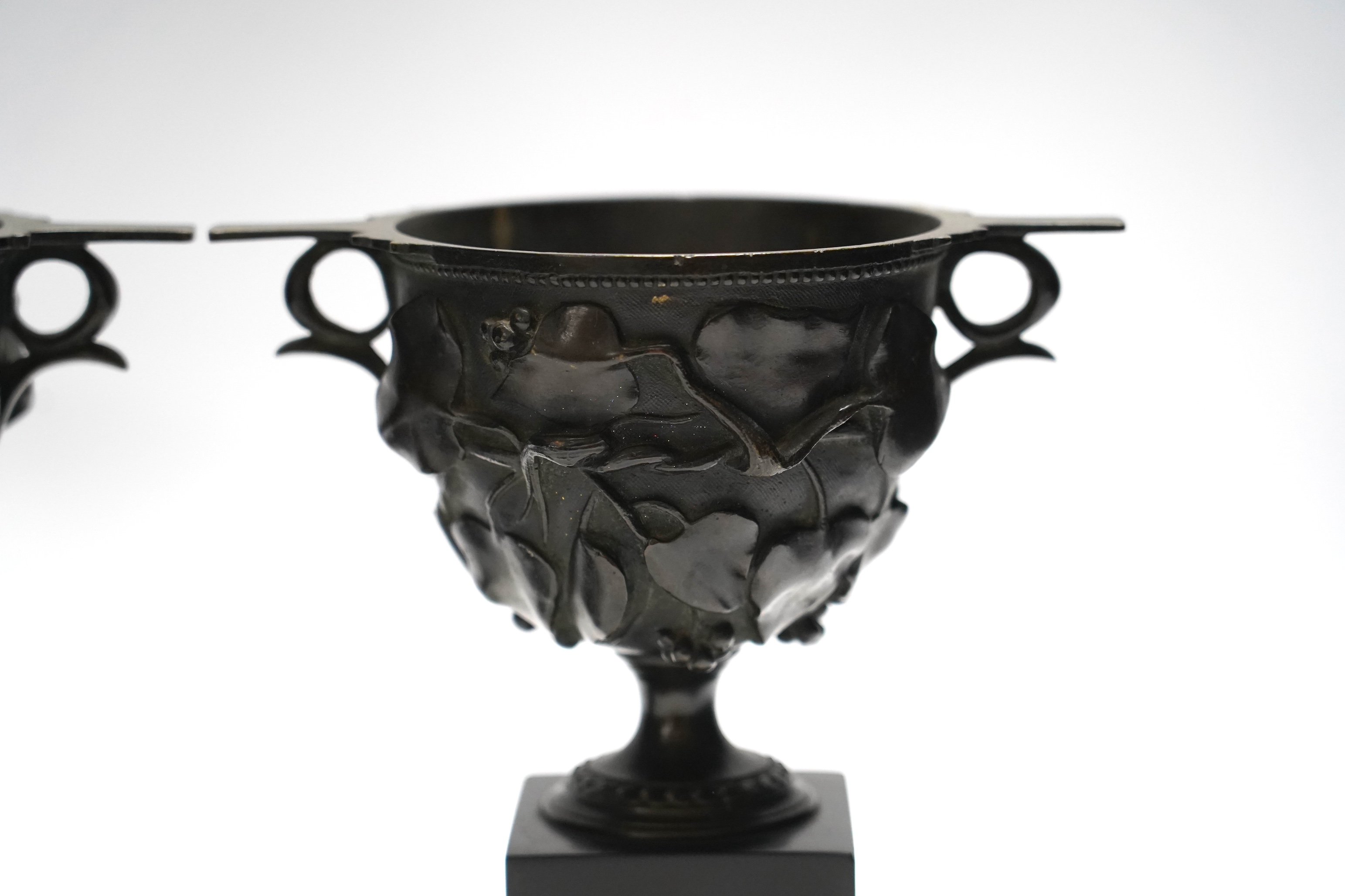 After the Antique, a pair of late 19th century bronze skyphos vessels on polished slate bases, 22cm